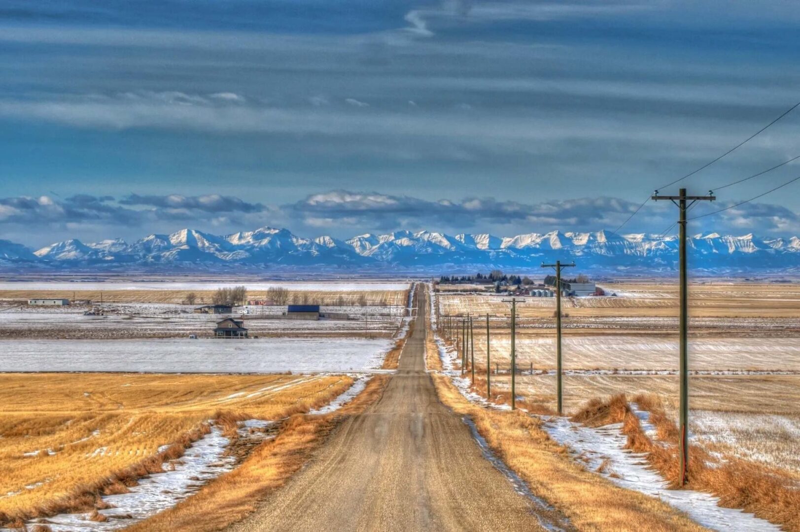 A dirt road with power lines on the side of it.